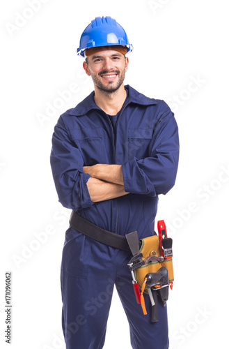 Portrait of a smiling young worker standing with arms crossed on white background