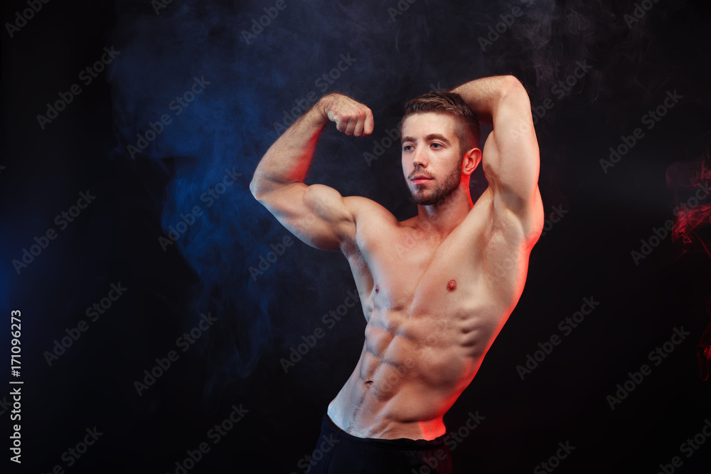 Bodybuilder man with perfect abs, shoulders,biceps, triceps and chest  flexing his muscles, studio shoot. Stock Photo