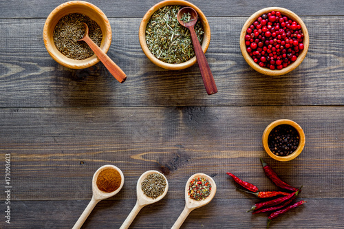 Kitchen table with spices and dry herbs on wooden kitchen background top view mock up