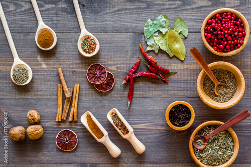 Spicy food cooking with spices and dry herbs wooden kitchen desk background top view