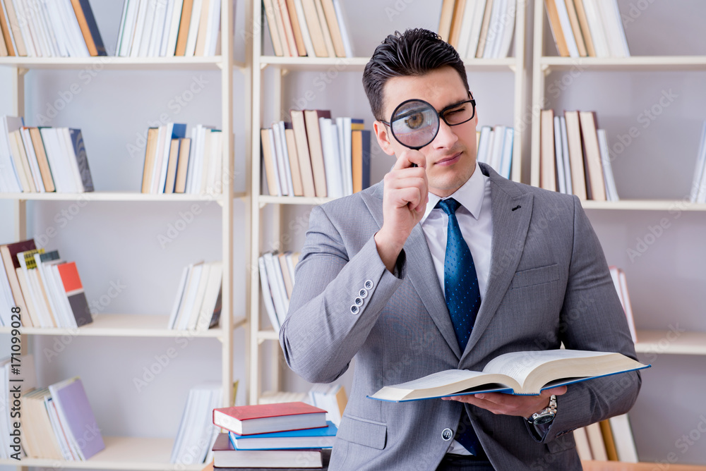 Business law student with magnifying glass reading a book Business law student with magnifying glass reading a book