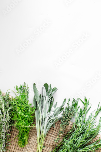 fresh herbs and greenery for spices and cooking on white desk background top view mock up