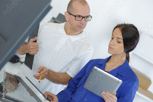 engineer training female apprentice on cnc machine