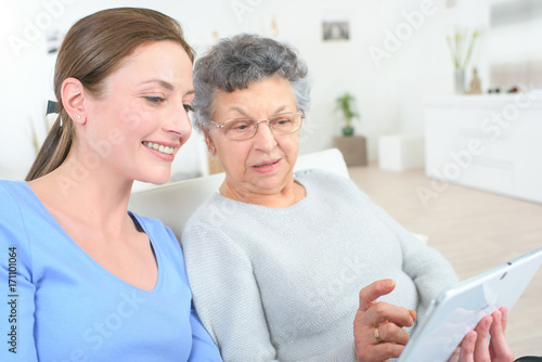 girl teaching internet with computer tablet to grandmother