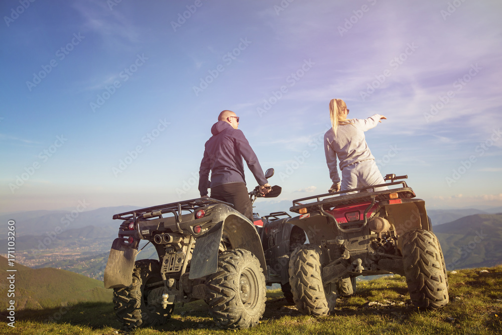 Obraz premium Couple driving off-road with quad bike or ATV
