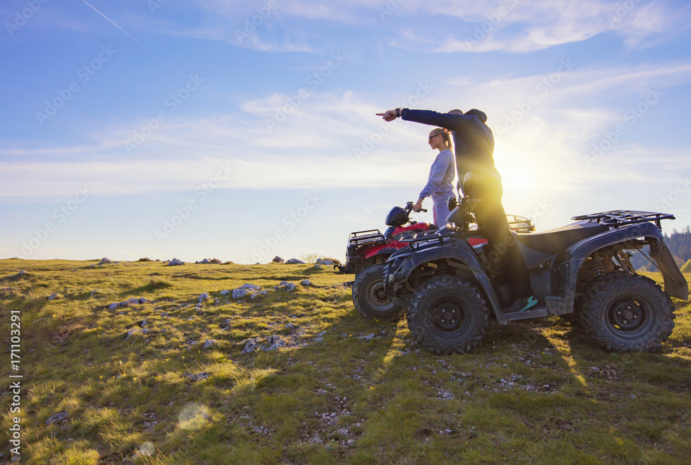 Couple driving off-road with quad bike or ATV Couple driving off-road with quad bike or ATV