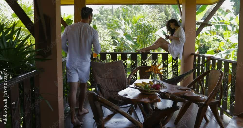 Man Bring Juice To Young Woman Use Cell Smart Phone Sitting On Balcony, Happy Couple Talking On Summer Terrace Slow Motion 60 Man Bring Juice To Young Woman Use Cell Smart Phone Sitting On Balcony, Happy Couple Talking On Summer Terrace Slow Motion 60
