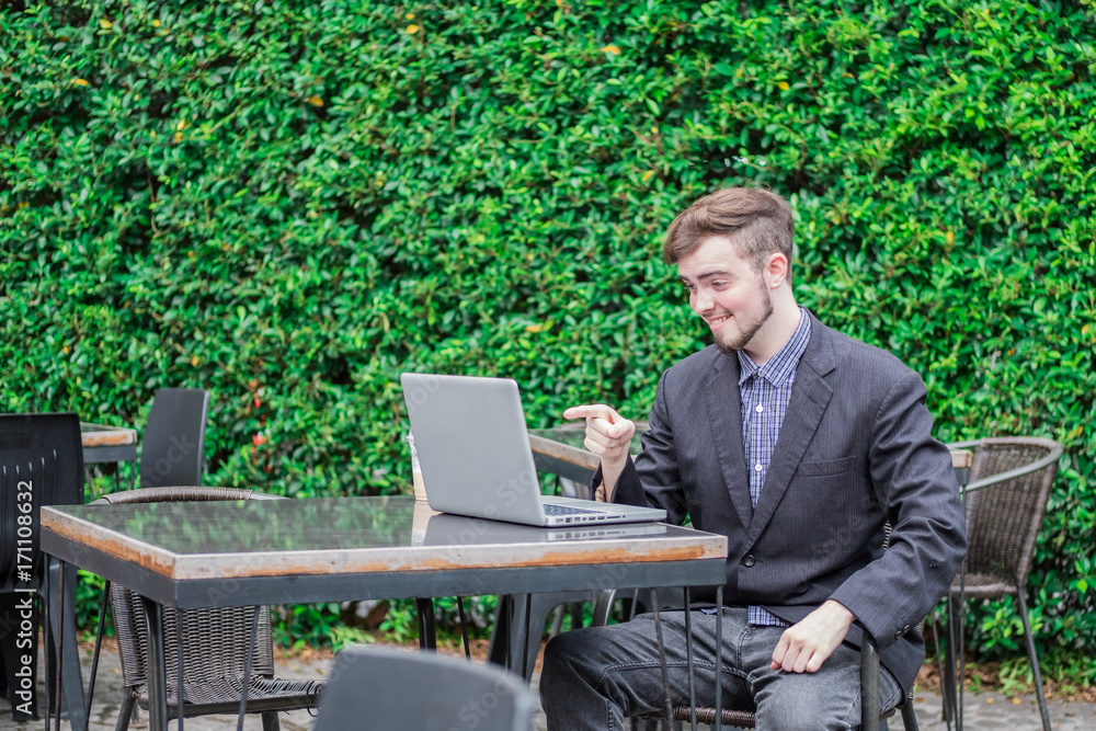 Looking for direction and inspiration, Portrait of happy young businessman sitting with laptop Looking for direction and inspiration, Portrait of happy young businessman sitting with laptop