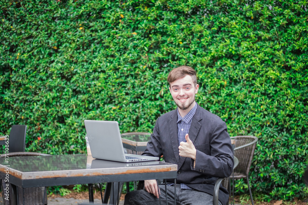 Looking for direction and inspiration, Portrait of happy young businessman sitting with laptop Looking for direction and inspiration, Portrait of happy young businessman sitting with laptop