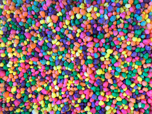 Close up on many colorful candy pieces. Bright colorful florescent colors. Flat lay top view background