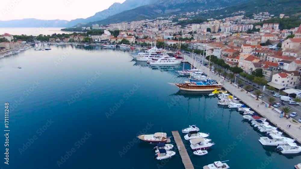 Aerial view on Makarska and marina at sunrise with Biokovo mountain in background. Makarska Riviera, Croatia Aerial view on Makarska and marina at sunrise with Biokovo mountain in background. Makarska Riviera, Croatia