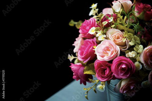 Decoration artificial flower in the vase over wood table