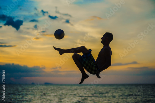 Kicking a ball. Silhouette of a man on a beach