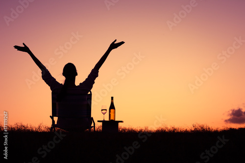 Freedom and joy. Happy woman sitting outdoors enjoying a beautiful sunset.