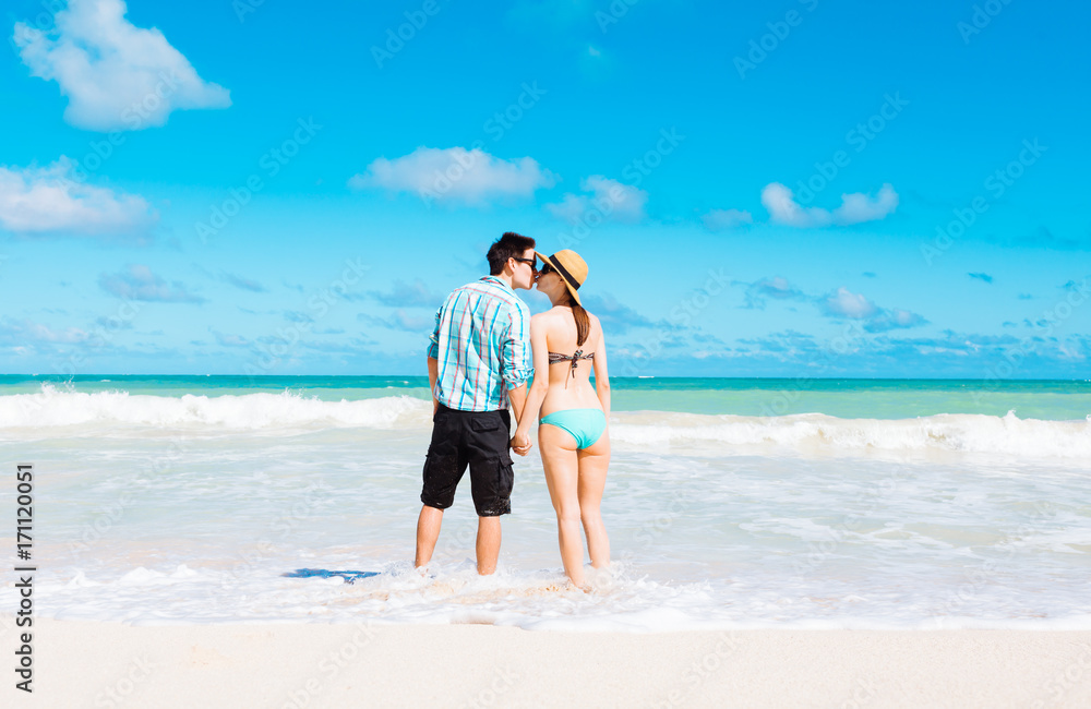 Young couple on the beach kissing. 