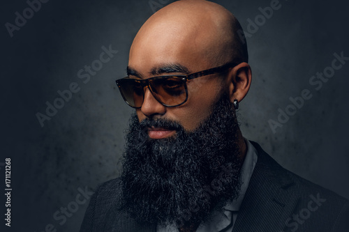 Arabic bearded shaved head male in sunglasses.