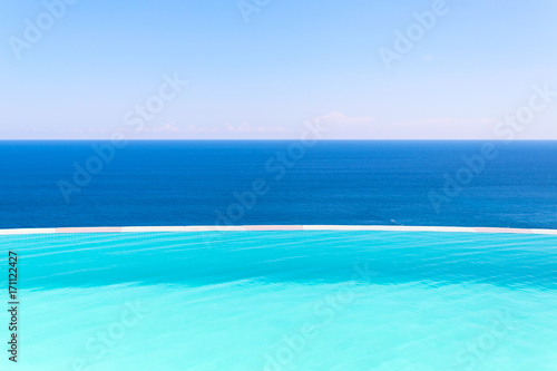 Swimming pool side on blue background of sea and sky