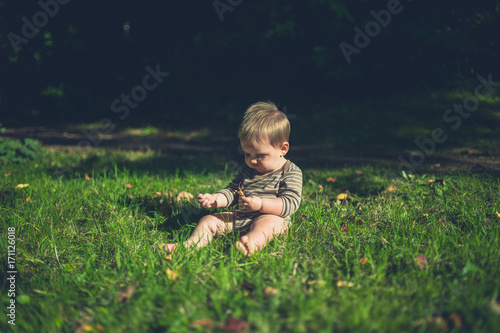 Little baby playing on the grass outside