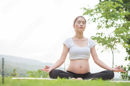 A woman sat cross-legged, her long hair tied back in a white shirt. The white shirt contrasted against her dark hair, creating a stunning contrast against her pale skin