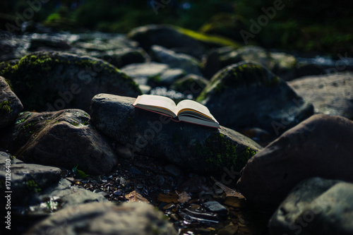 Open book on rocks in river