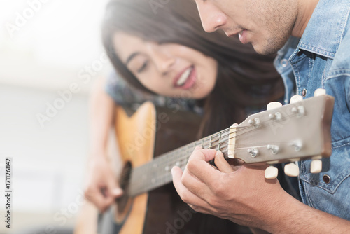 Couple playing acoustic guitar.