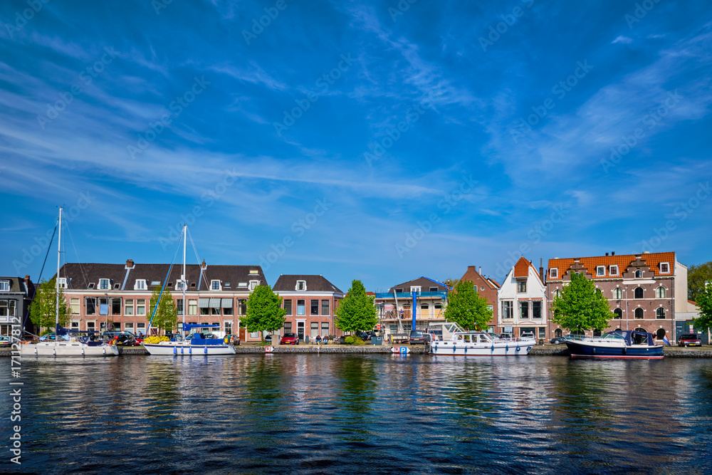 Boats and houses on Spaarne river. Haarlem, Netherlands