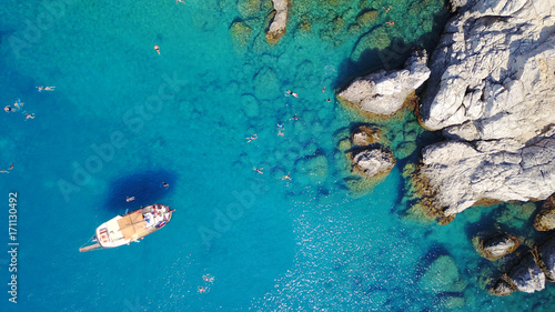 Fototapeta Naklejka Na Ścianę i Meble -  August 2017: Aerial drone photo of paradise beach of Traganou with small caves and turquoise clear waters, Rhodes island, Dodecanese, Aegean, Greece