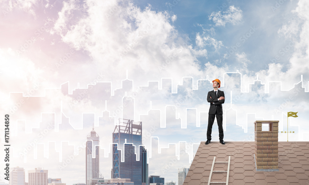 Engineer man standing on roof and looking away. Mixed media Engineer man standing on roof and looking away. Mixed media