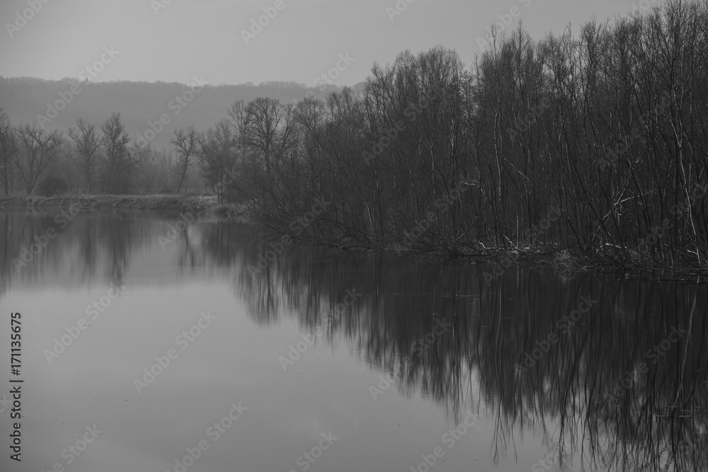 River and rolling hills, landscape in the countryside. Monochrome photo.