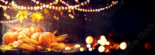 Fototapeta Thanksgiving Day background. Wooden table decorated with pumpkins and corncobs
