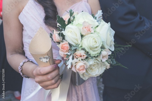 Donna che regge bouquet della sposa e coni di riso del matrimonio. luce vintage  photo