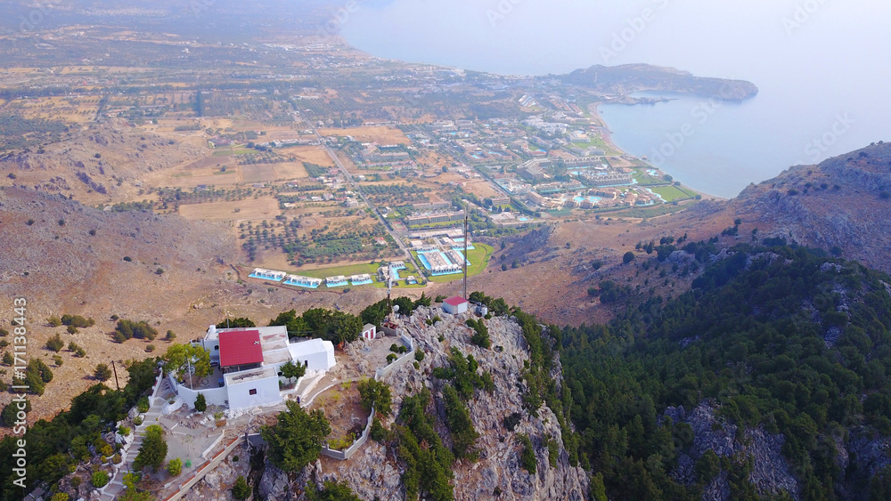 August 2017: Aerial drone photo of famous Tsabika monastery overlooking iconic Tsabika bay from the cliff with clear turquoise waters, Rhodes island, Aegean, Dodecanese, Greece