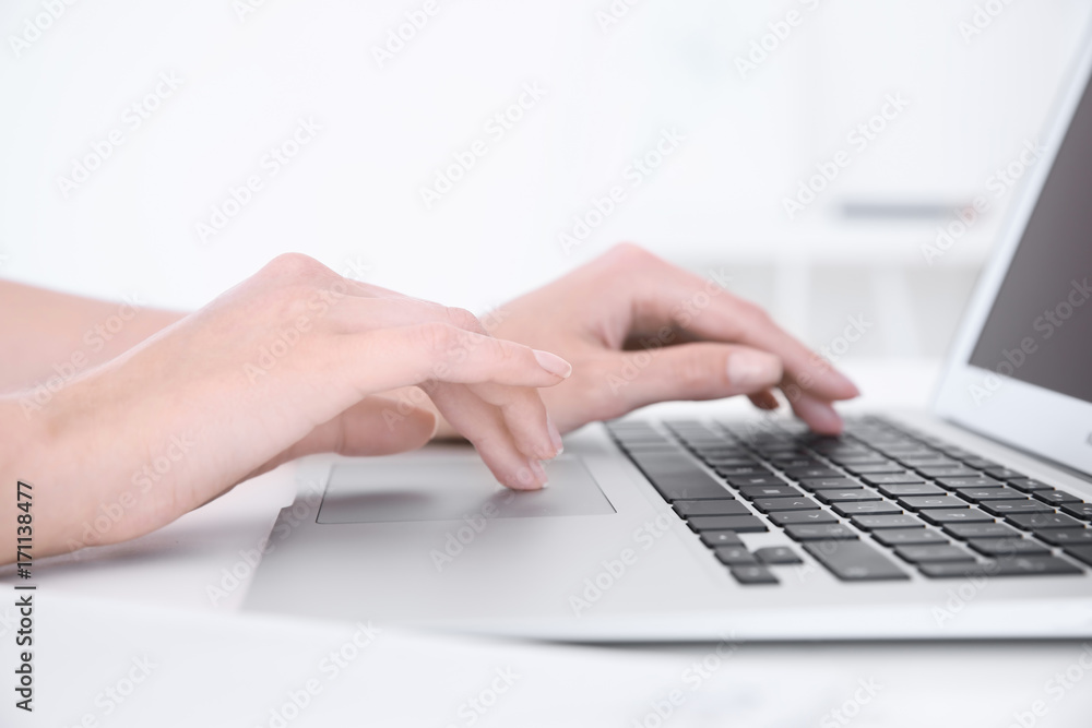 Young woman using laptop for searching information in internet at table Young woman using laptop for searching information in internet at table