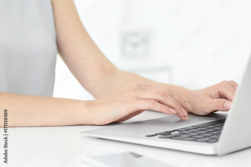 Young woman using laptop for searching information in internet at table Young woman using laptop for searching information in internet at table