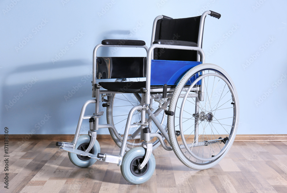 Wheelchair against color wall in room. Elderly care concept Wheelchair against color wall in room. Elderly care concept