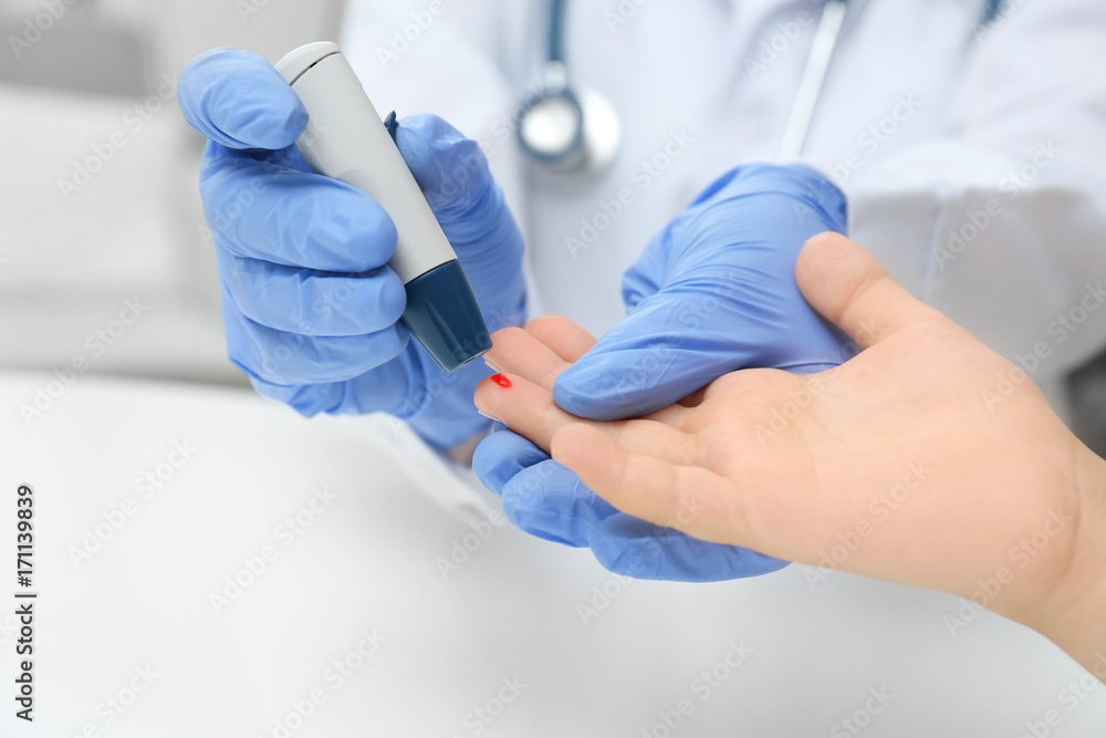Doctor in latex gloves taking sample of patient's blood using lancet pen. Diabetes concept Doctor in latex gloves taking sample of patient's blood using lancet pen. Diabetes concept