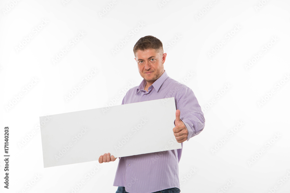 Young confident man portrait of a confident businessman showing presentation, pointing paper placard gray background. Ideal for banners, registration forms, presentation, landings, presenting concept. Young confident man portrait of a confident businessman showing presentation, pointing paper placard gray background. Ideal for banners, registration forms, presentation, landings, presenting concept.