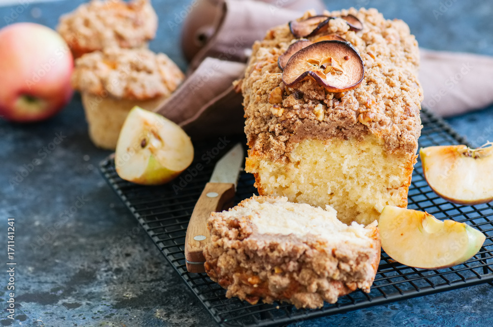 Apple cinnamon streusel cake on a wire rack on a blue stone background. View from above. Apple cinnamon streusel cake on a wire rack on a blue stone background. View from above.