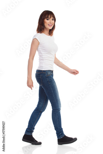 Smiling Young Woman Is Walking And Looking At Camera