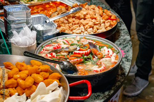 Variety of cooked Chinese food on display for takeaway at Camden Market in London