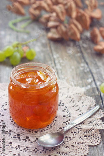 Slatko - white grape jam (sweet), traditional serbian desert; white grapes in syrup in a glass jar photo