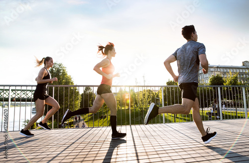 Photography Young athtletes in the city running at the river.
