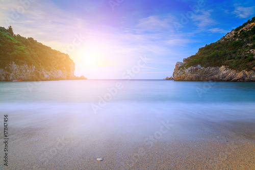 Long exposure landscape of Paleokastritsa famous sand beach in close bay on Corfu island at dusk, Ionian archipelago, Greece.