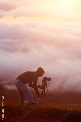 Photographer shooting natural phenomenon - the clouds that roam the mountains. Concept theme: nature, weather, tourism, extreme, healthy lifestyle, adventures. Unrecognizable persones.