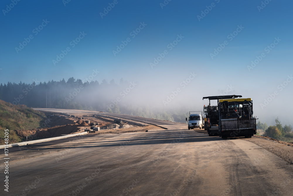 Road construction works with roller compactor machine and asphalt finisher