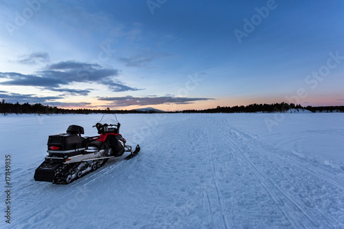 motoneige sur un lac gelé au lever du soleil en Laponie Swedoise