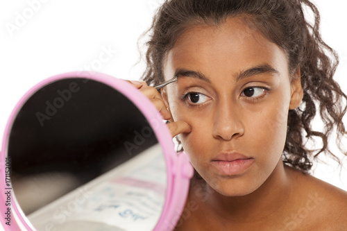 Wall Mural young beautiful black woman pluck her eyebrows