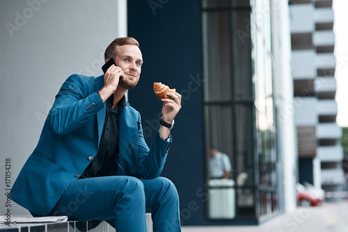 Foto Handsome young businessman talking on phone
