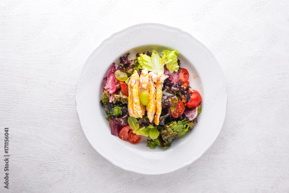 Vegetable salad with chicken and mango sauce on a wooden background. Top view. Free space for text. Vegetable salad with chicken and mango sauce on a wooden background. Top view. Free space for text.