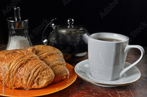 Still life with a cup of tea and croissants